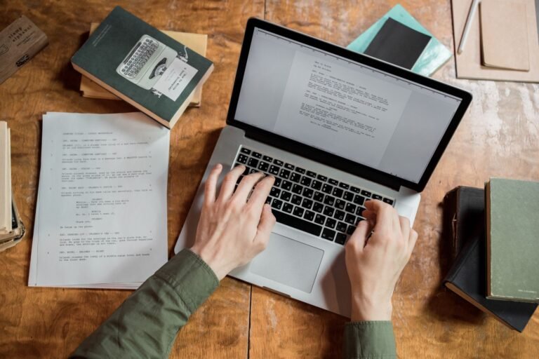 Author working on a manuscript and laptop