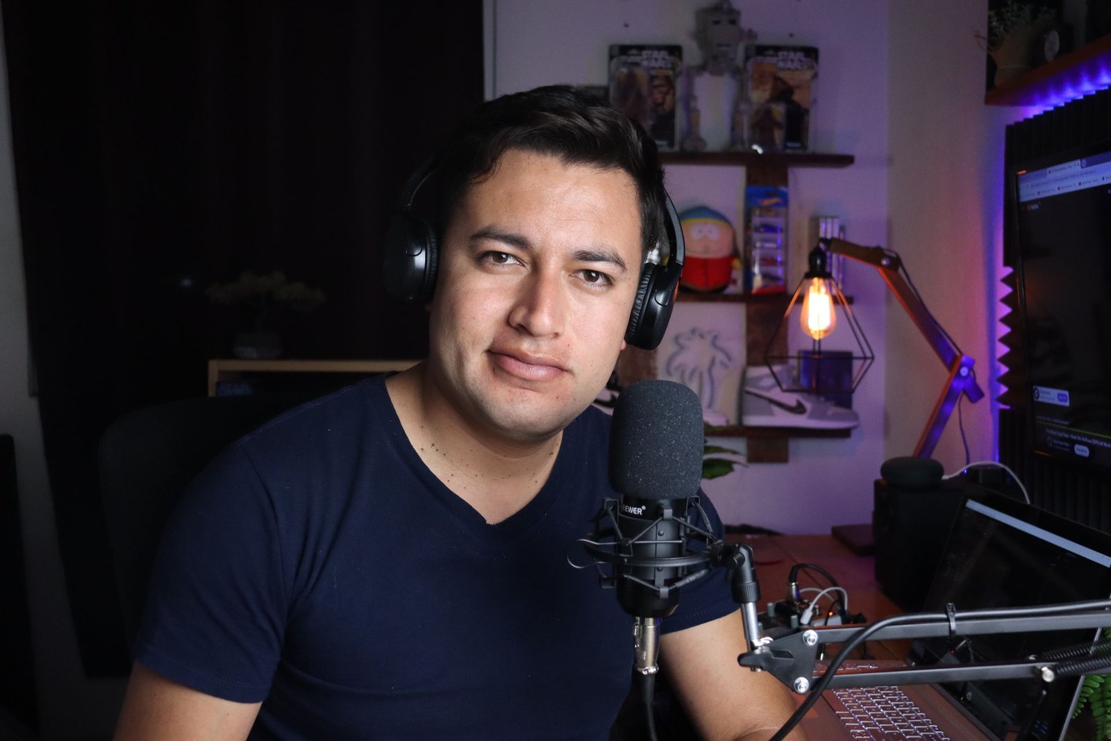 Narrator in a home studio with headphones and microphone