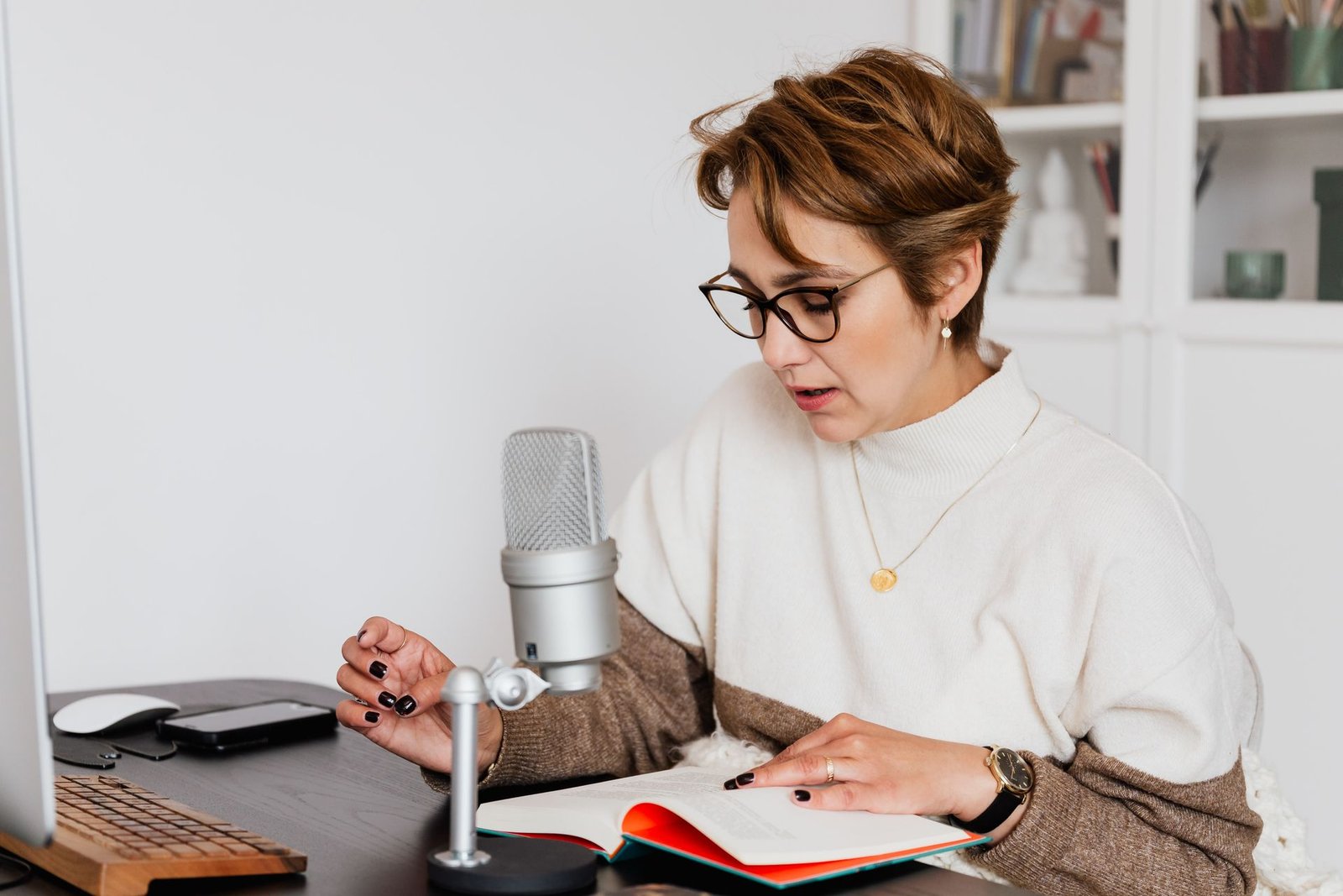 Self-narrating author reading her book aloud at a home recording desk